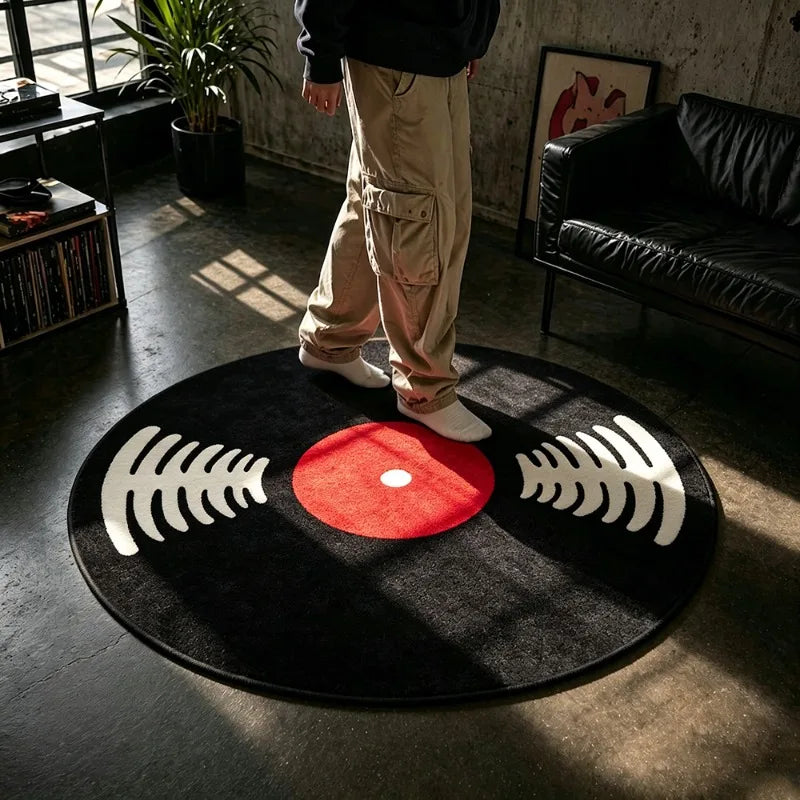 A round black rug with white sound wave patterns and a red center placed on a dark floor.