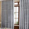 Light gray vintage floral blackout curtains framing a wooden door and window.