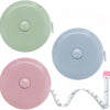 A set of two flexible body measuring tapes in light green and pink colors with a ruler.