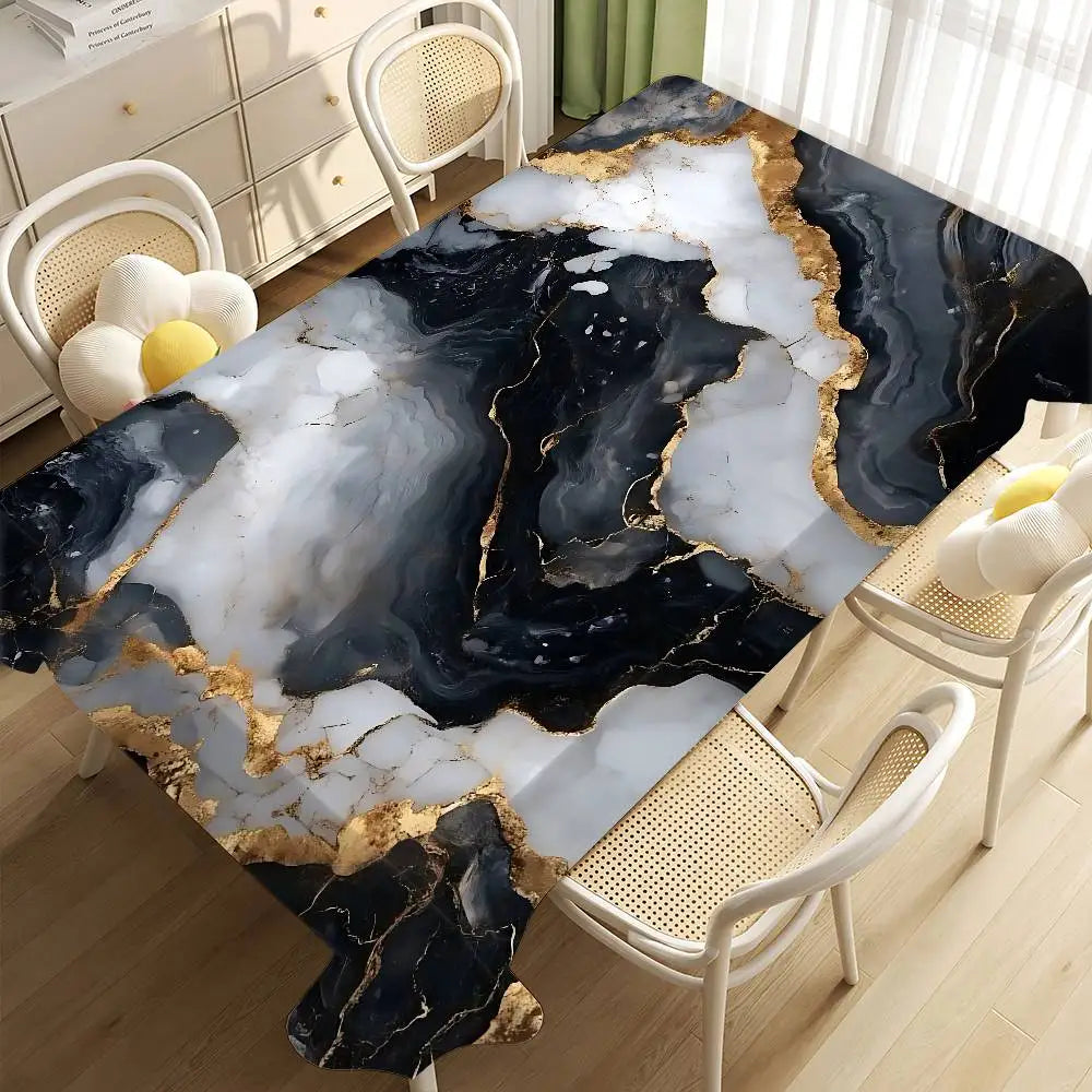 A dark marble pattern table cloth featuring white and gold veining placed on a wooden floor with white chairs.