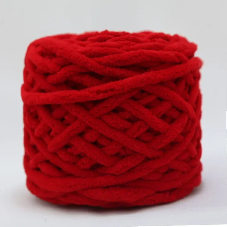 A ball of bright red chenille knitting yarn coiled tightly.