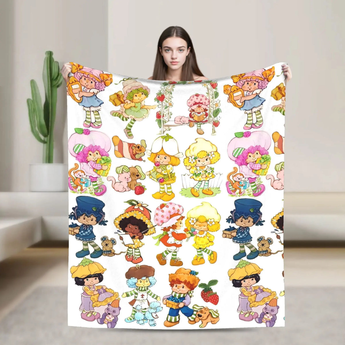 A colorful illustration of various Strawberry Shortcake characters on a plush throw blanket.