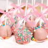 Pink cake pops decorated with sprinkles and tied with pink satin ribbon bows