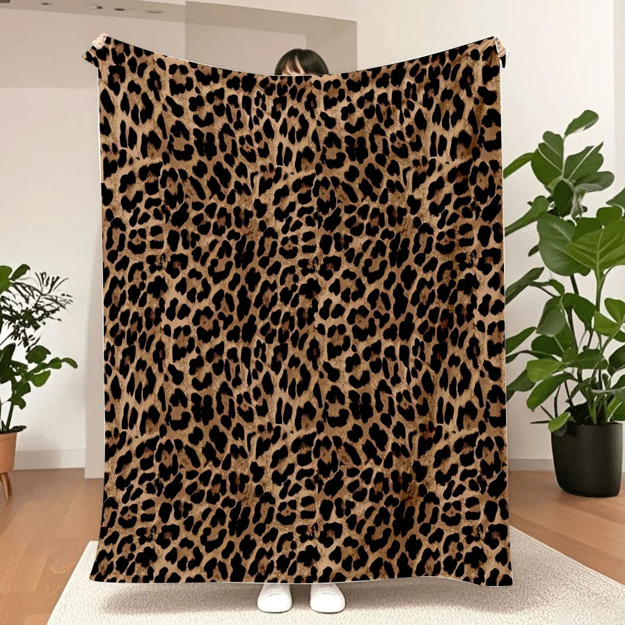 A luxurious leopard print flannel blanket displayed flat against a white background.