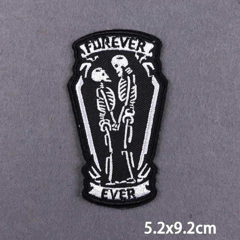 Black embroidered patch featuring two skulls and the word forever on a dark background
