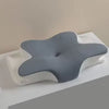 A gray cooling memory foam cervical pillow resting on a white towel or surface.