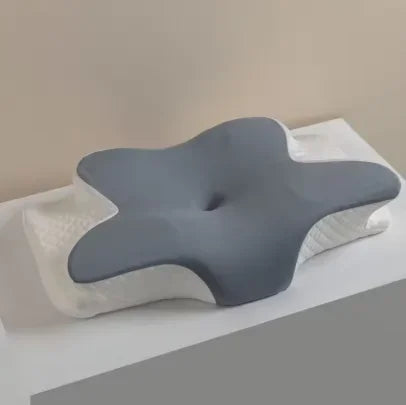 A gray cooling memory foam cervical pillow resting on a white towel or surface.