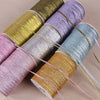 Rolls of 10-meter gold and silver glitter satin ribbon in various shades displayed diagonally.
