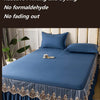 A navy blue embroidered cotton bedspread and pillow set with gold trim.
