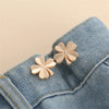 Gold-toned butterfly button clips attached to a denim fabric