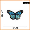 A set of five embroidered butterfly and rose iron-on patches, featuring blue and yellow details.
