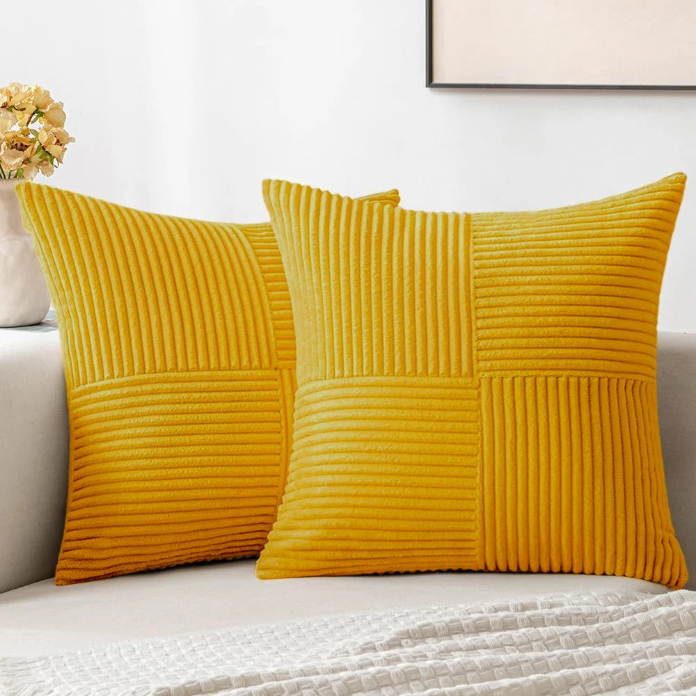A set of four yellow corduroy throw pillow covers with a vertical ribbed texture and a patchwork design.