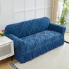 A deep blue anti-slip jacquard sofa slipcover is displayed on a light-colored floor in a bright room.