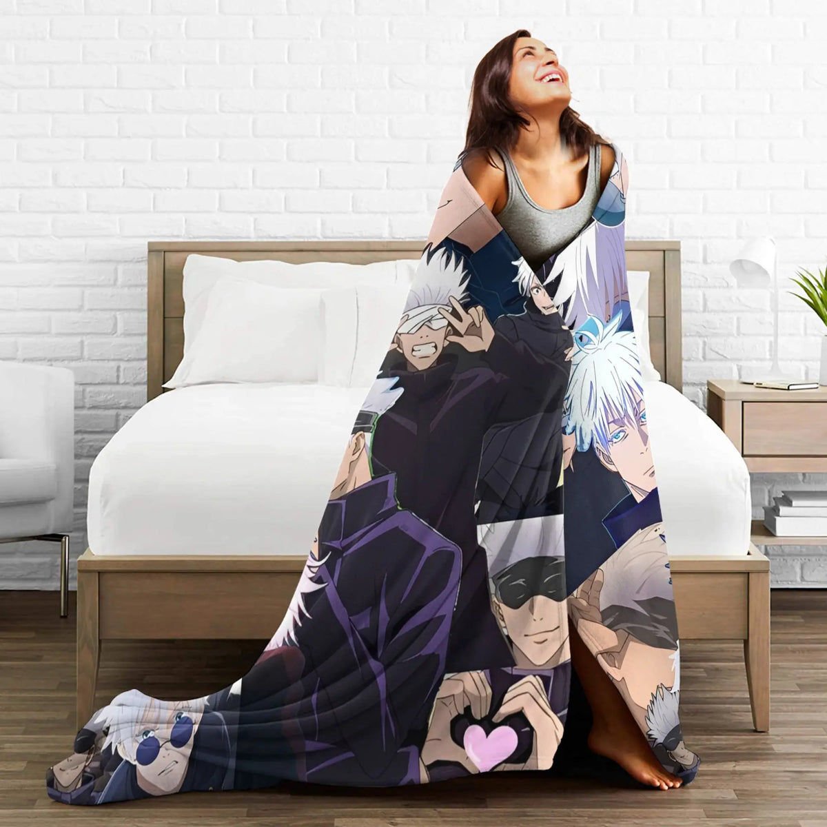 A woman is relaxing on a bed with a Jujutsu Kaisen Gojo Satoru flannel throw blanket draped over her.