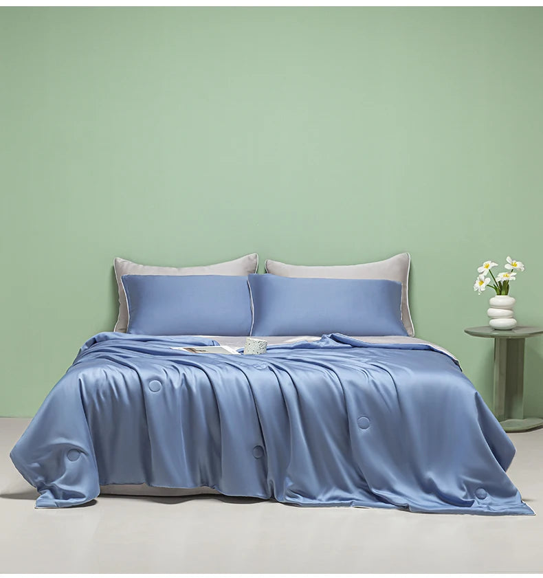 A light blue ice silk cooling quilt is displayed on a bed against a pale green wall.