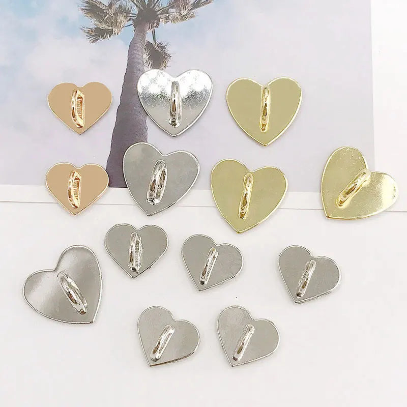 A collection of heart-shaped metal phone charm connectors in silver and gold finishes.