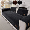 A black striped sofa cushion with light beige trim and a brown accent, shown on a white sofa.
