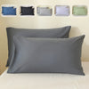 A set of five luxury polyester pillow covers in various shades of blue, gray, and green displayed on a bed.