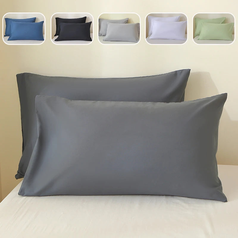 A set of five luxury polyester pillow covers in various shades of blue, gray, and green displayed on a bed.