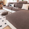 A brown removable jacquard seat cushion cover on a sofa with light beige pillows and a white rug.