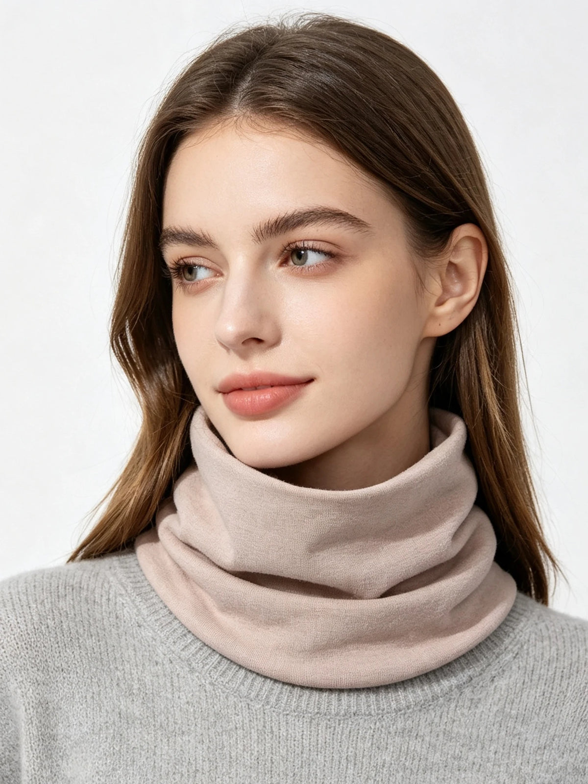 A woman models a beige soft cotton warm neck scarf over a gray sweater.