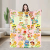 A colorful plush throw blanket featuring various Strawberry Shortcake characters in a pink and green pattern.