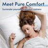 A woman rests her head on a white bed pillow, demonstrating pure comfort.
