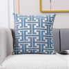 A blue and beige geometric patterned lumbar pillow cover resting on a gray sofa.