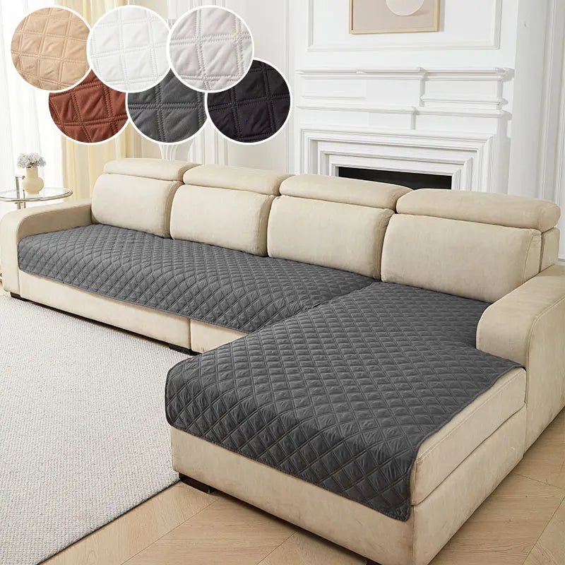 A beige sofa with a dark gray quilted cushion cover and decorative round cushions.