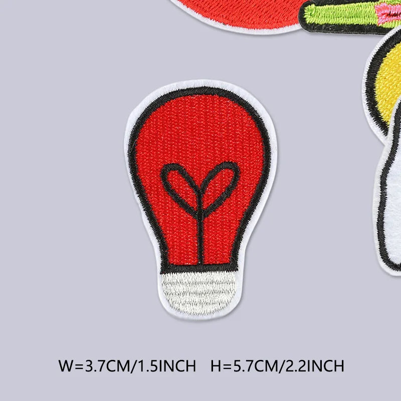 A red iron-on patch shaped like a heart inside a light-colored oval, used for clothing embroidery.