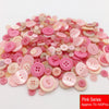 A pile of assorted pink resin sewing buttons in various shades and sizes for crafting projects