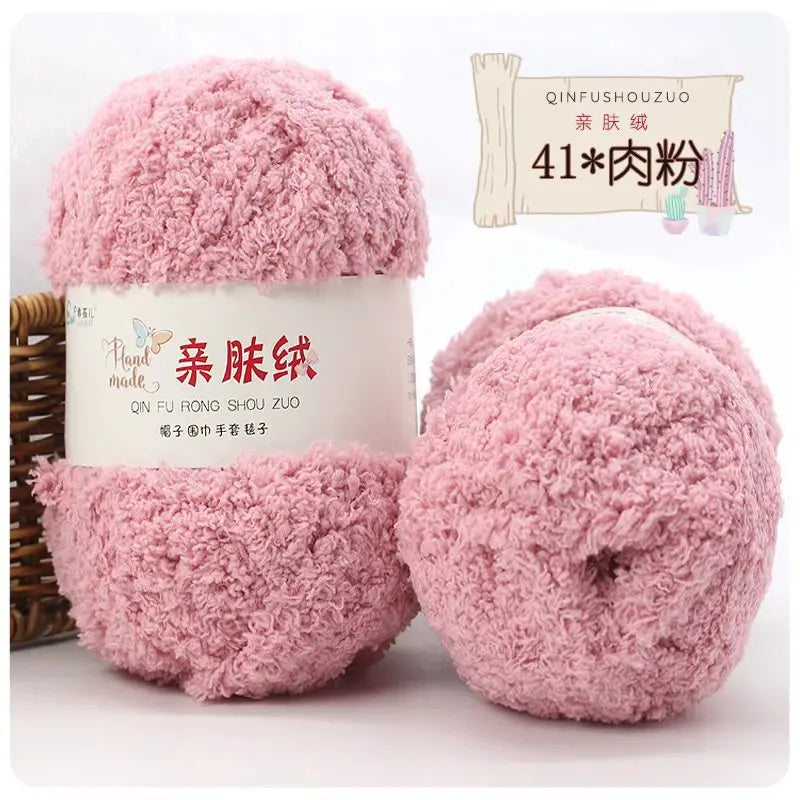 Pink fluffy velvet yarn in a cylindrical container with a wooden stick and small pink cactus for scale.