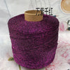 A spool of vibrant purple glitter metallic yarn for crochet and knitting