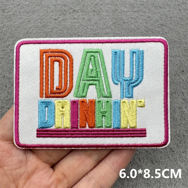 Pink embroidered patch with the text DAY DRINKS in colorful block letters.