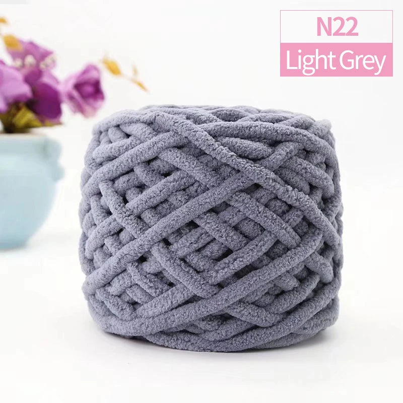 A ball of light grey chunky velvet knitting yarn used for home decor.