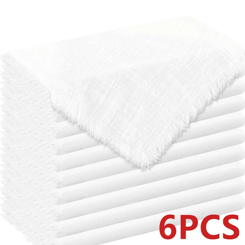 A stack of six white decorative cloth napkins shown from the side.