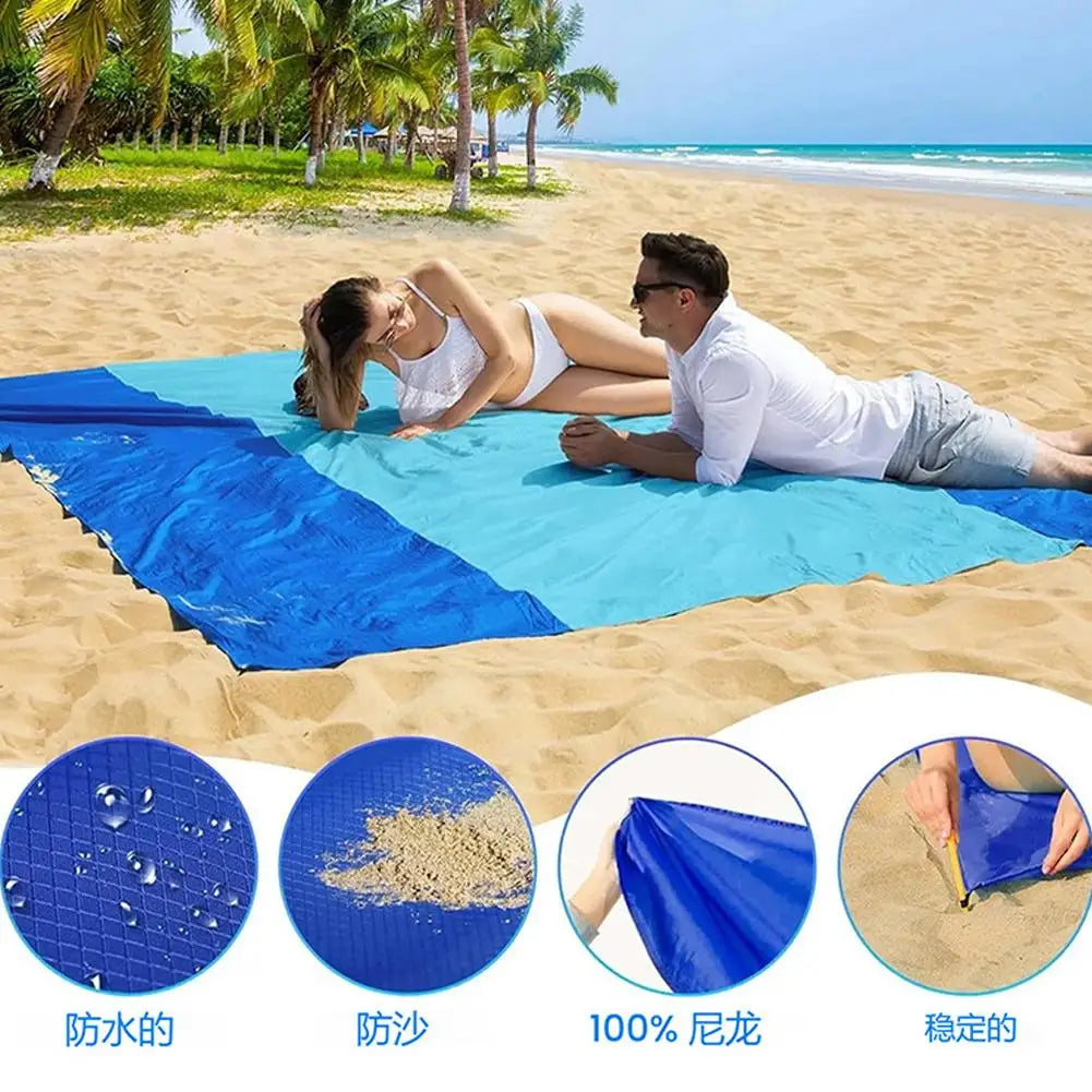 Blue foldable waterproof outdoor picnic mat shown on a sandy beach with a person relaxing on it.