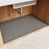 A waterproof silicone mat liner is placed inside a wooden under sink cabinet for drainage and protection.