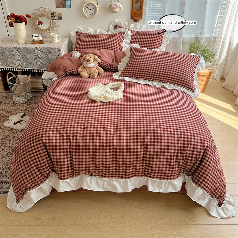 A plaid duvet cover set featuring red and brown checks with white lace embroidery displayed on a bed.