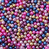 A close-up of many small, round imitation pearl beads in various shades of pink, purple, blue, and gold.