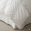 Pure white princess ruffle cotton bedding set folded on a bed