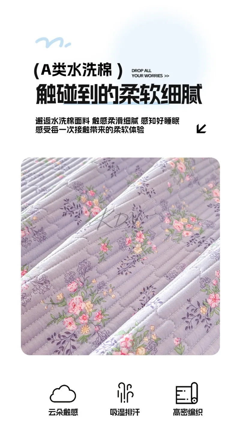 A luxury floral quilted bedspread featuring soft pink and purple tones with delicate floral embroidery.
