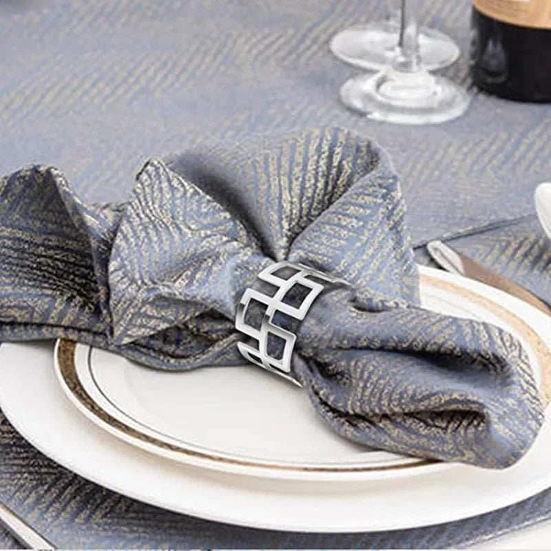 Elegant metal napkin rings in a blue and silver striped pattern placed on a white plate.