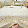 A luxury floral quilted bedspread with a light yellow and green pattern is displayed on a bed.