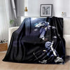 A black flannel blanket featuring a graphic design of a person in a blue suit with white accents.