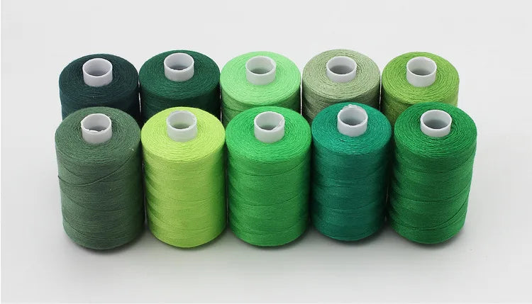 A row of ten spools of 10-color polyester sewing thread in various shades of green and olive.