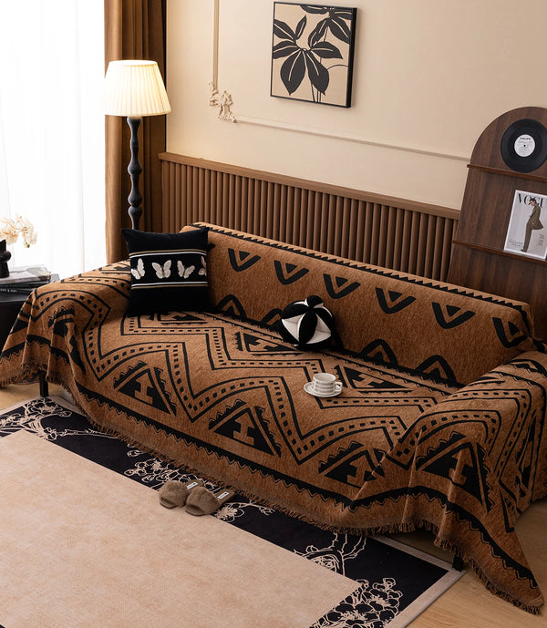 A brown vintage pattern sofa throw blanket draped over a sofa, featuring geometric designs.