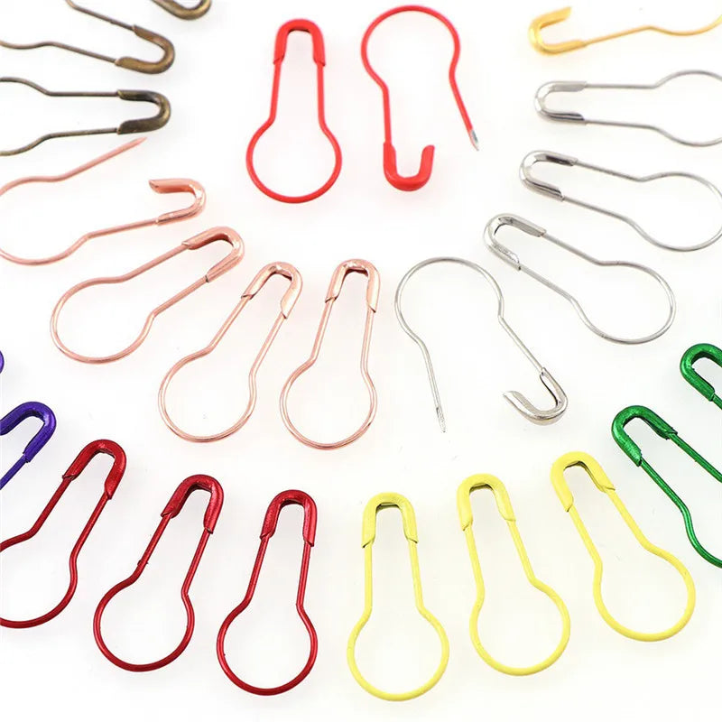 A collection of colorful safety bulb pins for knitting and sewing in various colors like red, pink, silver, and green.