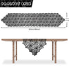 Black lace spider web table runner displayed on a wooden table.