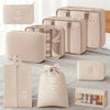 A set of beige and cream travel storage organizers including pouches, a toiletry case, and a fabric bag.